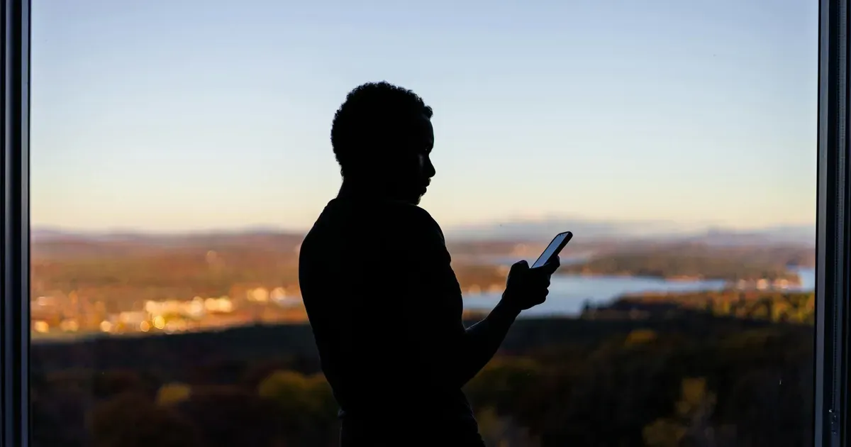Digitální památník na obrazovce telefonu u náhrobku s QR kódem