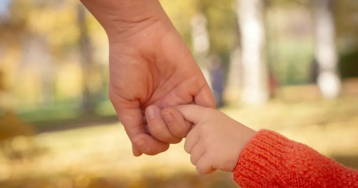 Pohřeb dítěte — svíčka a květiny jako symbol vzpomínky